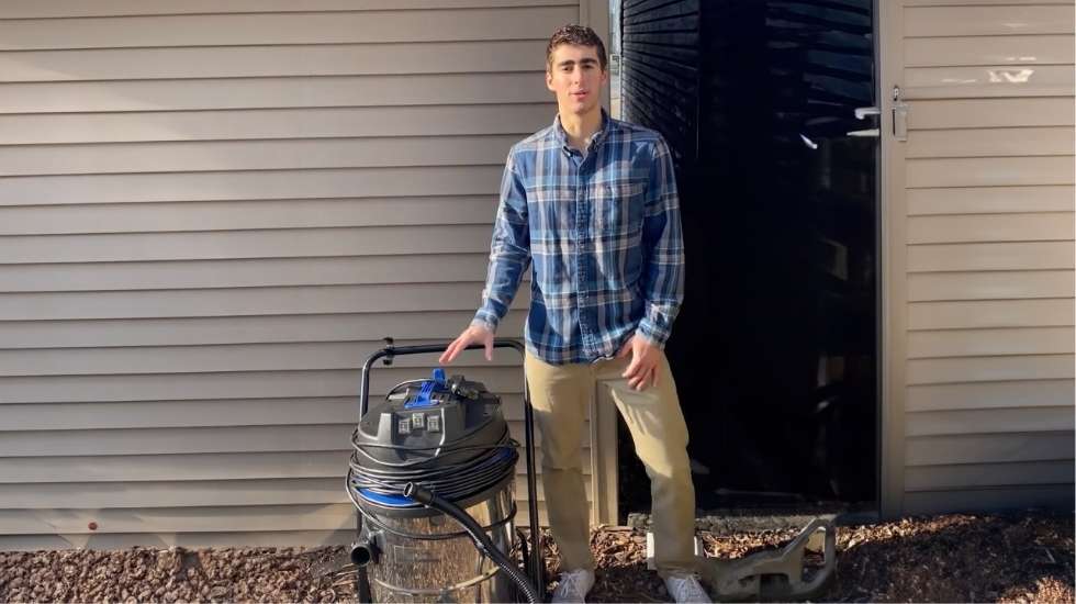 Man standing next to a Classic Cyclone Gutter Cleaning Vacuum outside a house